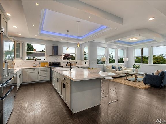 Coffered ceilings with customizable lighting, kitchen opens to living/dining room. 