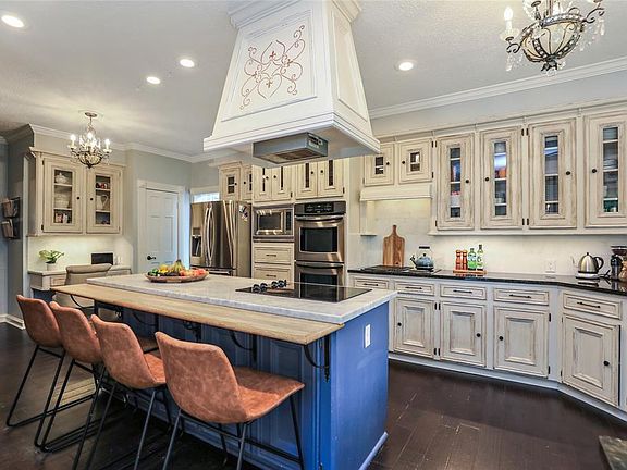 LARGE KITCHEN ; This kitchen is a chef's dream! A large island with seating, cabinets with glass inserts, double ovens, double ranges, marble and granite counters, and a built-in desk area make this kitchen the heart of this home.