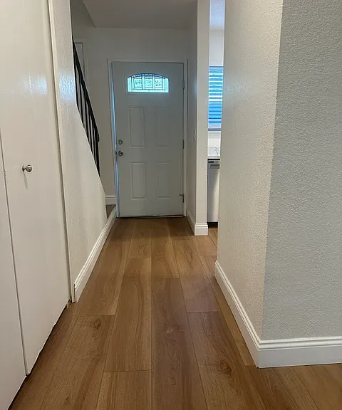 Looking from downstairs bathroom towards the front door and stairs to the left