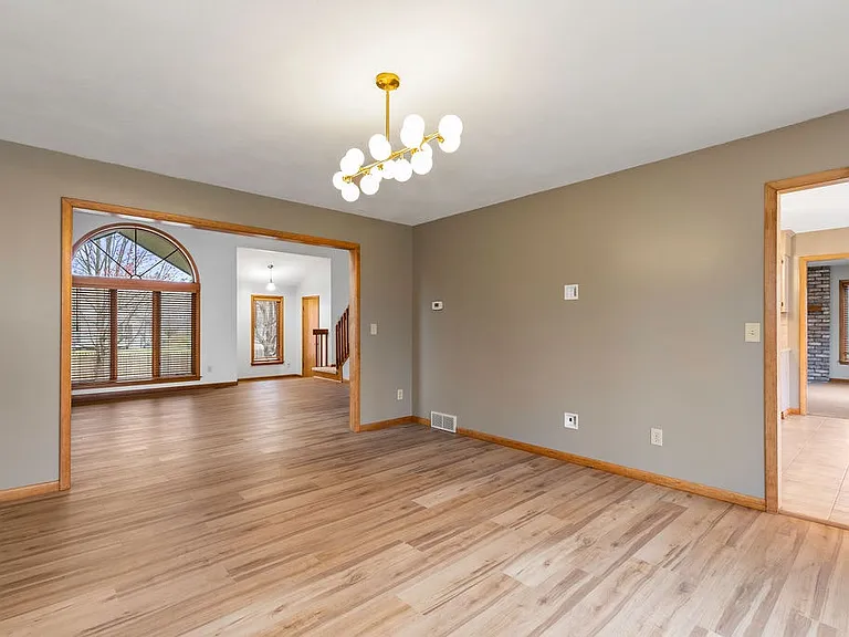 Formal dining room is flanked by the kitchen and the floral living room. Room for even the largest gatherings
