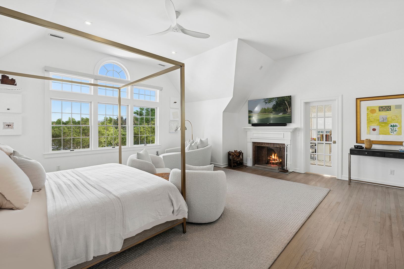 Spacious primary with double-sided fireplace, vaulted ceiling