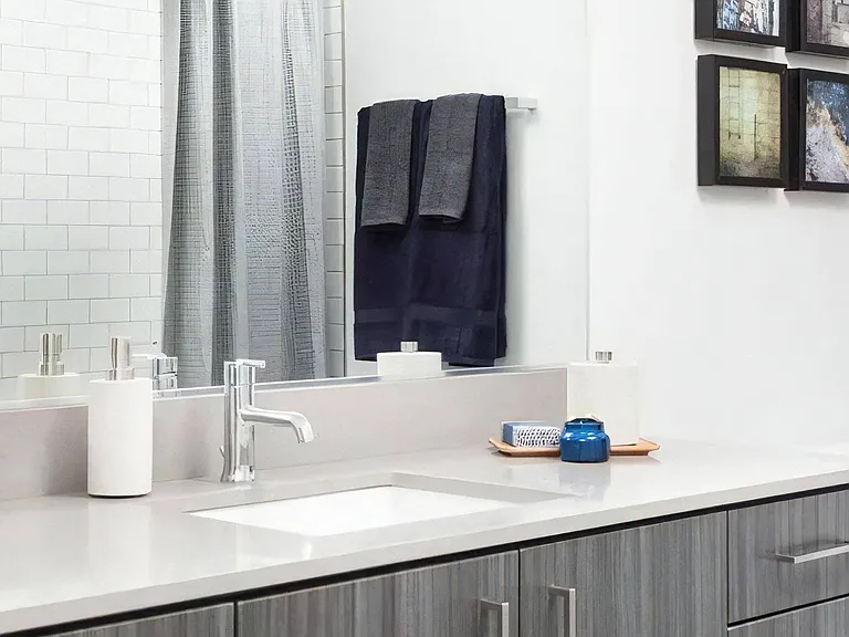 Vanity Area with Undermount Sink, Tile Wall, and Framed Artwork