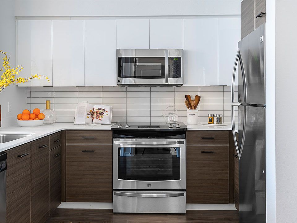 Apartment Kitchen with Stainless Steel Appliances, quartz counters and wood floors.
