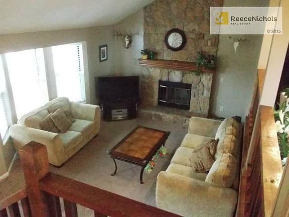 Beautiful stone fireplace with vaulted ceiling in living room.