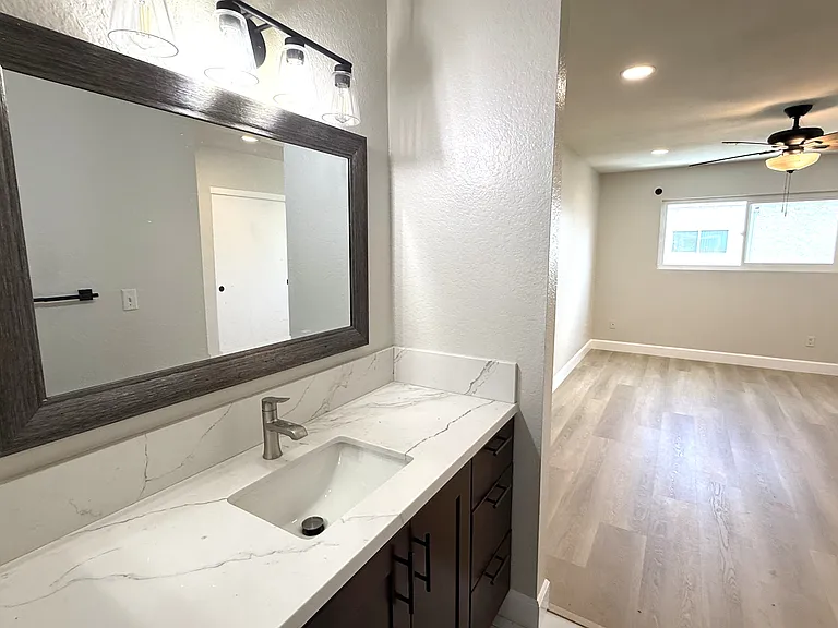 Primary vanity with view of bedroom