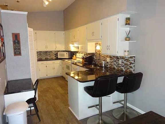 Updated kitchen with granite countertops and tiled backsplash.