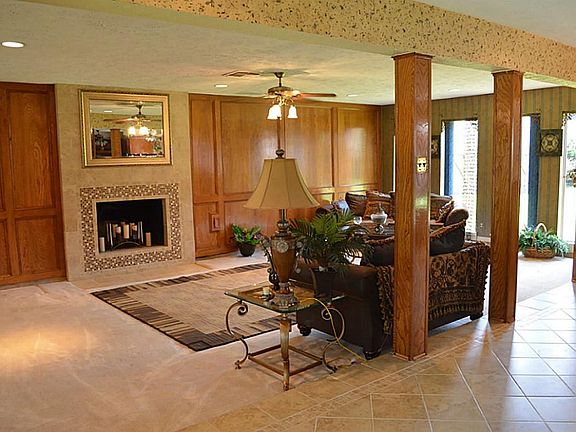 The family room has tile flooring, handsome wood paneled walls and a cozy tile framed gas fireplace.