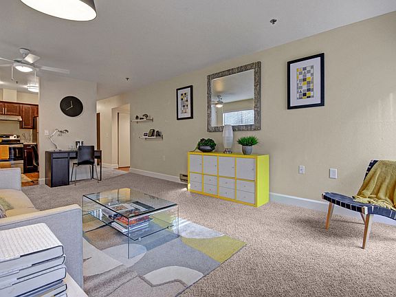 Living room with couch, desk, and view into the kitchen