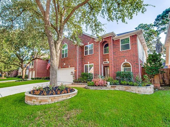 Professionally landscaped front yard with stained privacy fence.
