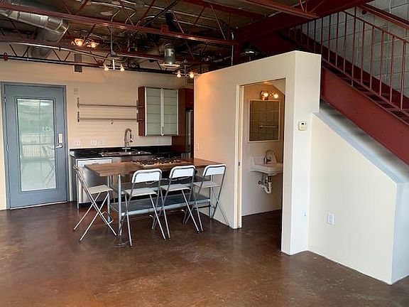 Open main floor layout of two story loft featuring 1/2 bath, dining area, and kitchen.