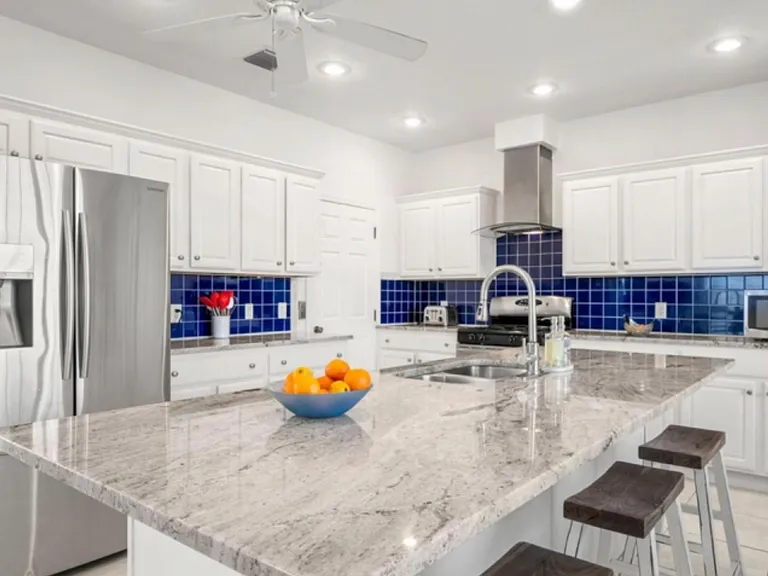 Kitchen with stainless steel appliances, granite countertop, gas stove, microwave, utensils