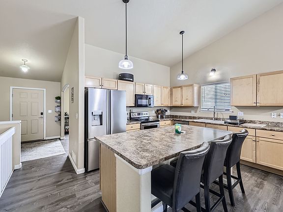 This expansive kitchen island serves as the heart of the space, offering plenty of room for meal prep, casual dining, or entertaining.