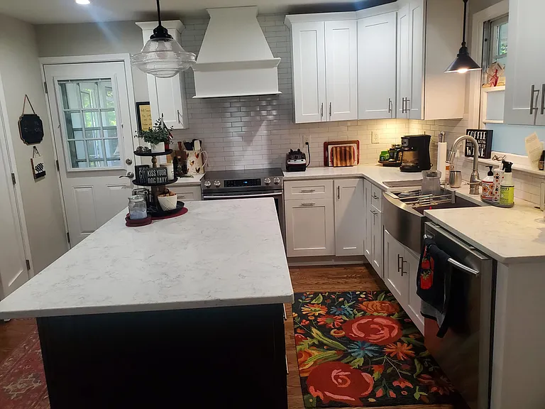 Renovated kitchen features a large island with extra storage, quartz countertops, new SS appliances, farm sink.