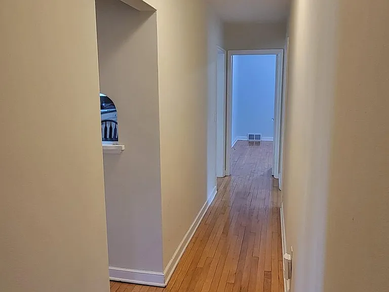 Main floor hall from outside bathroom. Bedroom 1 is at the far end of the hall.