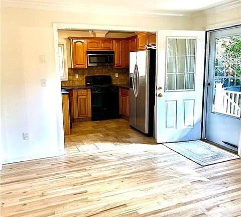 Living area with kitchen opens to back balcony