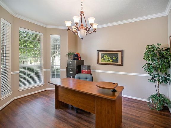 Formal dining room right off the entry boasts laminate flooring, chair rail, crown molding and elegant light fixture.
