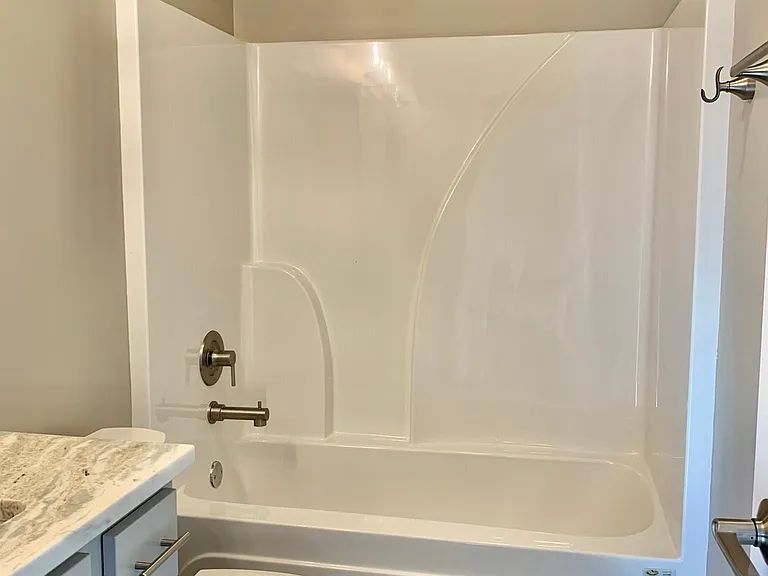 Full bathroom off of hallway leading to second bedroom
