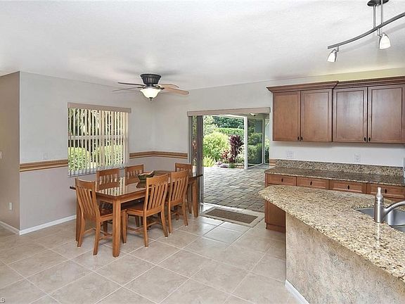 Dining area off of the patio area. Large neutral tiles throughout.