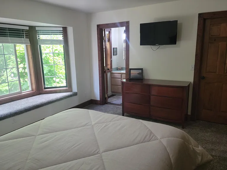 View from master bedroom towards master bathroom. Television in master bedroom.
