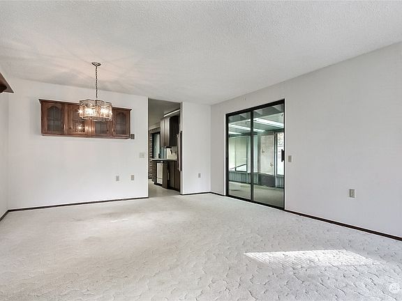 View of dining room from living room, kitchen straight ahead and sun/3-seasons room through patio doors.>