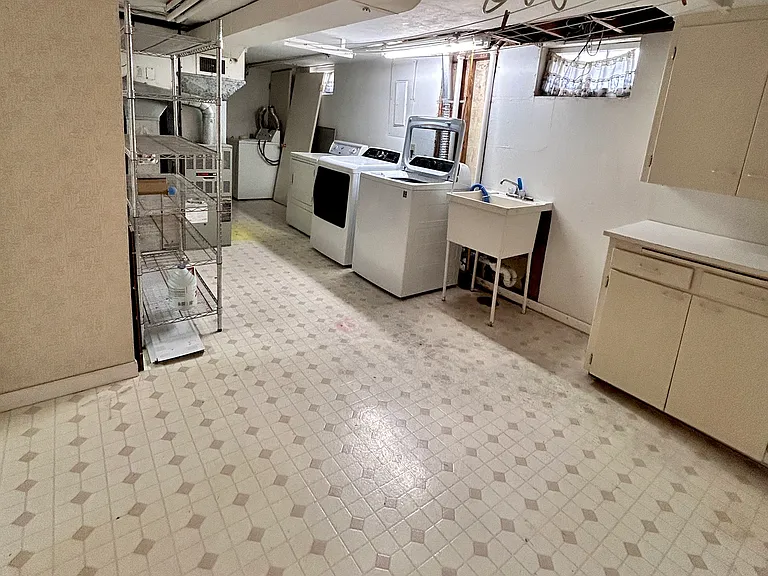 spacious basement laundry/storage room with washer/dryer