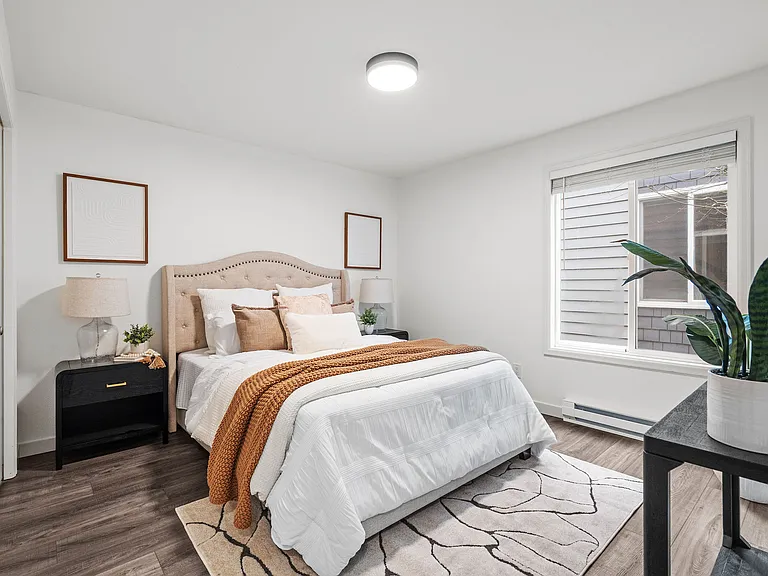 Primary bedroom with large window and natural light streaming in