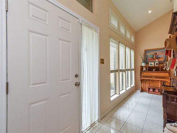 Light & Bright entryway. White, large tiles, with the wall of windows, with custom shutters to block sun when necessary, but let light in when comfortable.
