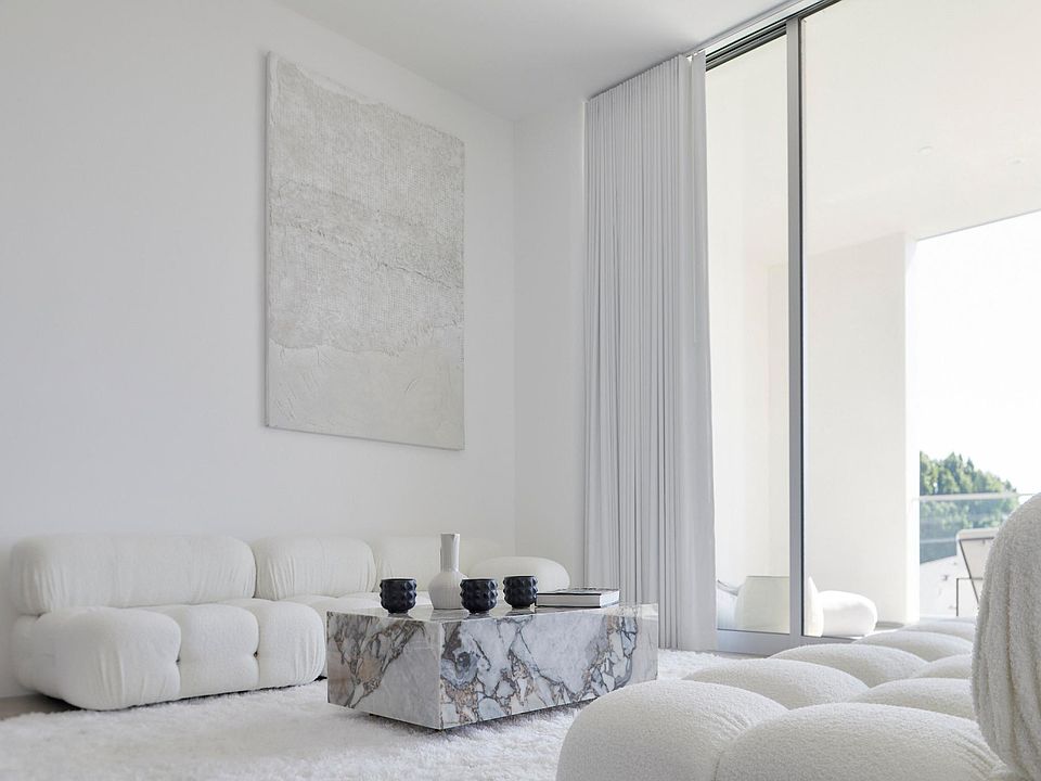 Living Area with Sunlit Interiors _ Designed for comfort and sophistication, this living space features an open-concept design, oversized glass sliding doors, and high-end finishes that enhance the sense of tranquility.