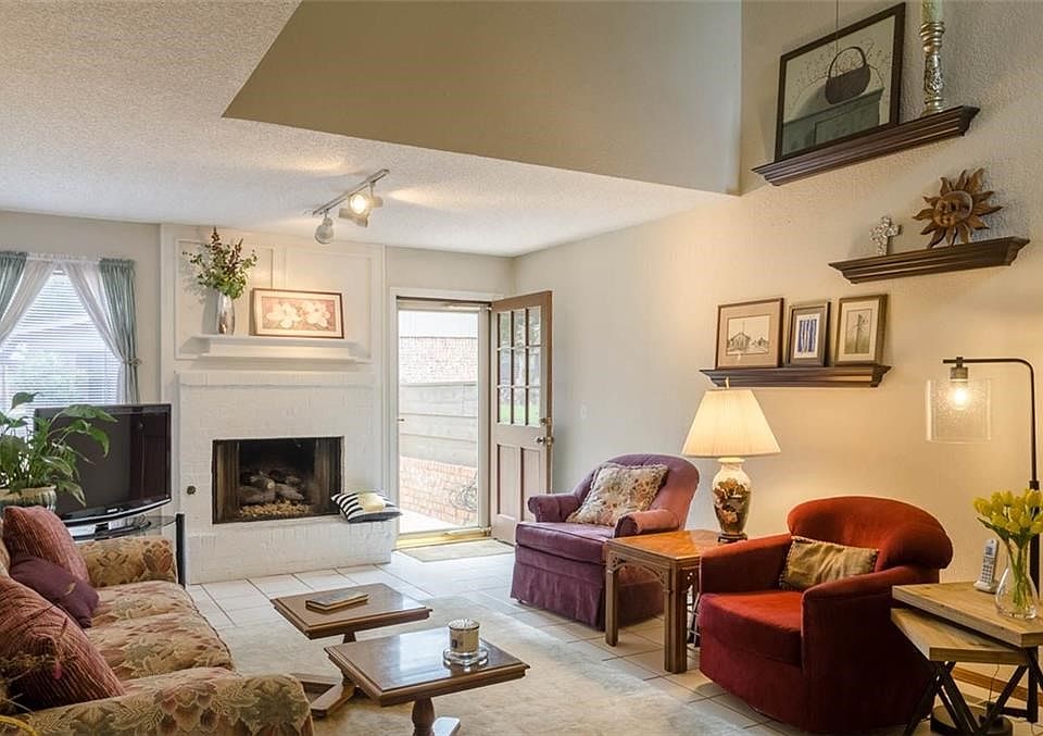 Pretty Living room with tile floors and fireplace. Back door opens onto open patio, overlooking greenbelt.