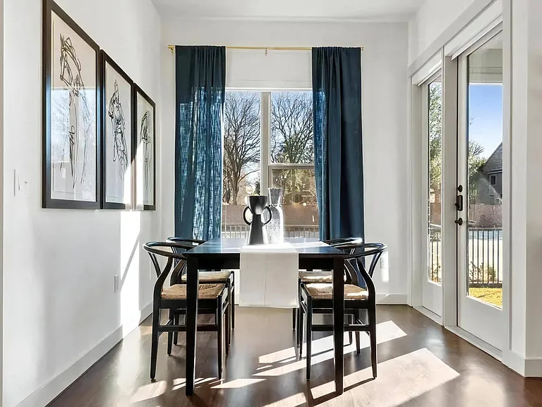 Four-Seat Dining Table Next to Sliding Glass Doors and Window