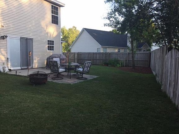 Large fenced in backyard with patio
