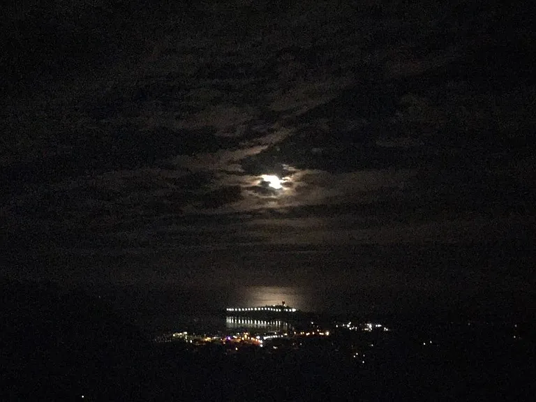 View to west of setting moon over Pillar Point Harbor after dark