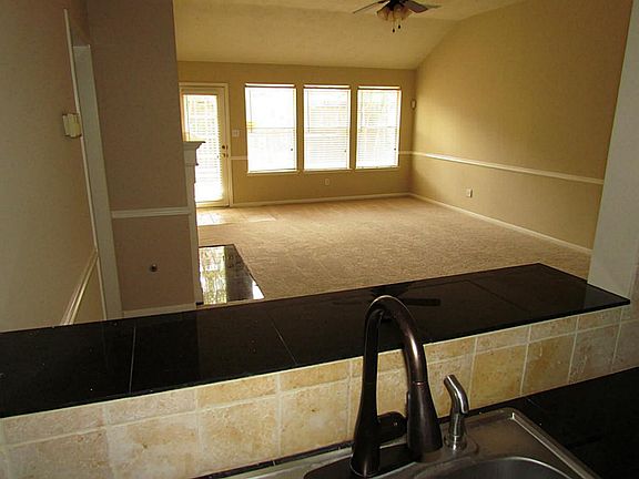 The kitchen opens to the living room with a bar area.