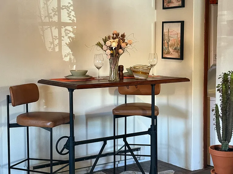 Dining area that converts into a flexible workspace. Sit or stand with monitor, ideal for remote work.
