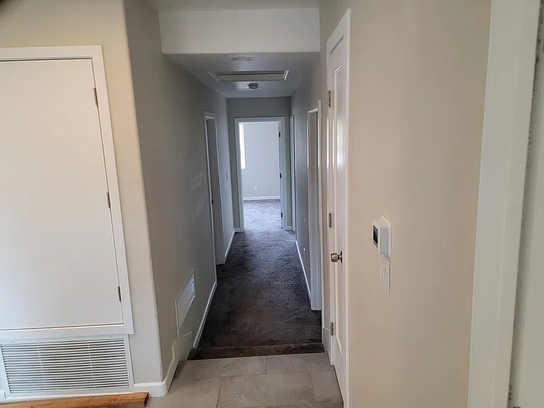 hallway leading to three bedrooms