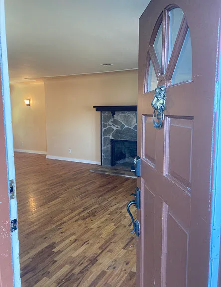 View inside living room from front door. Please note: fireplace is not operable.