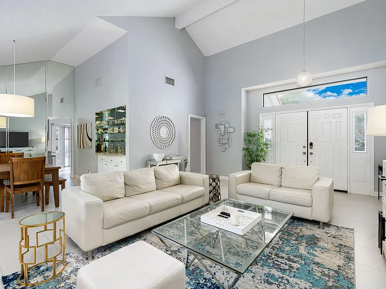 Living room area with dining room and bar at left.