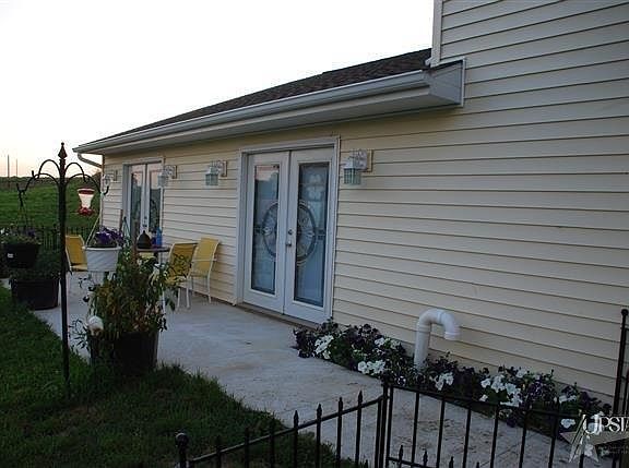 Two bay window doors open out to view of the field and lake