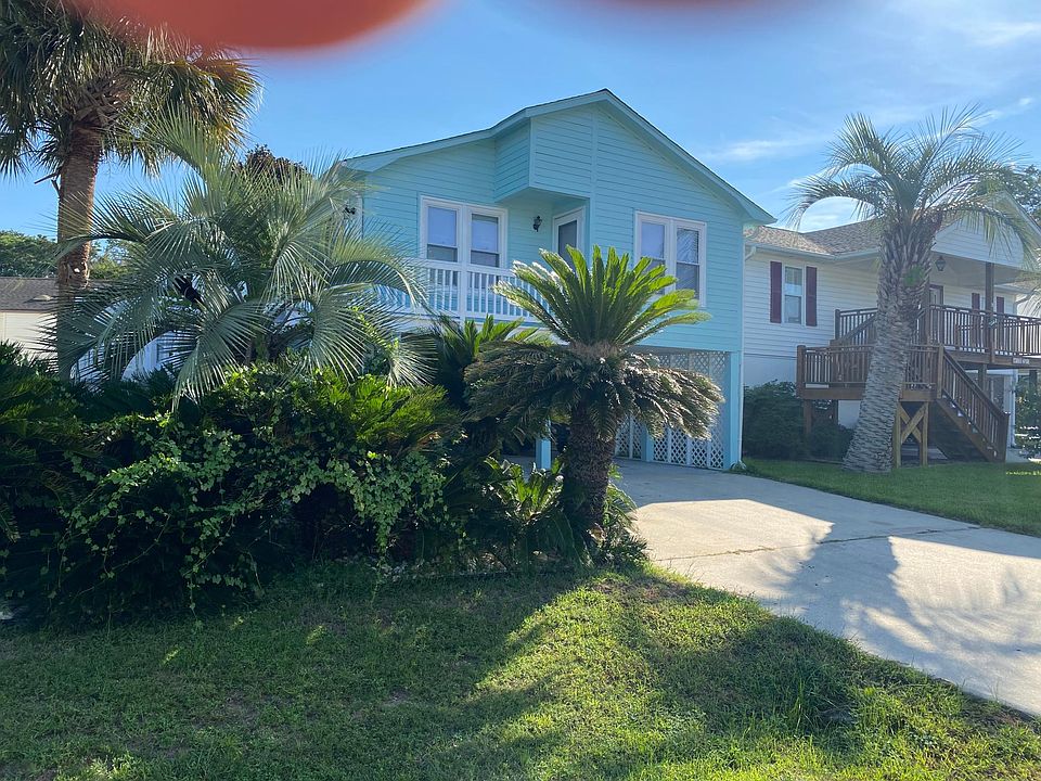 The front of the house, has a wonderful Sago and palm tree garden, a small yard that is very easy to maintain. Driveway has lots of parking underneath the one and outside too.