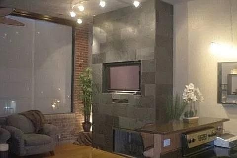 Living room with slate fireplace that has a custom TV area, can set a 47" TV in enclosure or mount up to 60".