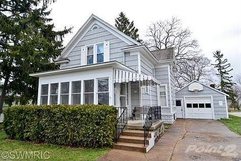 Lovely village home with enclosed/covered porch, side drive and attached garage.