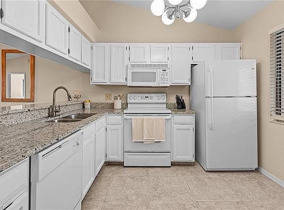 Fully stocked kitchen with dishes, glassware, untensils, pots and pans.