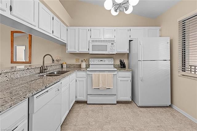 Fully stocked kitchen with dishes, glassware, untensils, pots and pans.