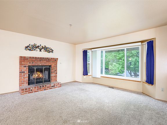 Living room has a large window and wood-burning fireplace