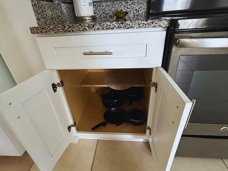 Well-equipped kitchen with pots, pans, and paper towels.