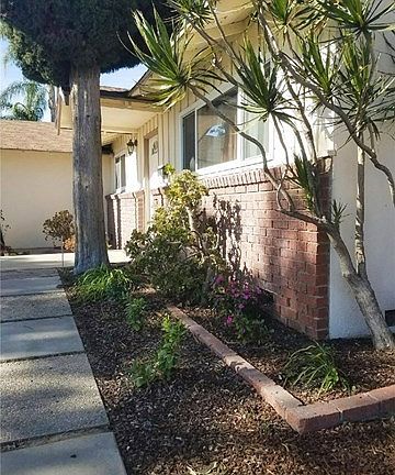 Side View of the exterior with flower beds and new landscape