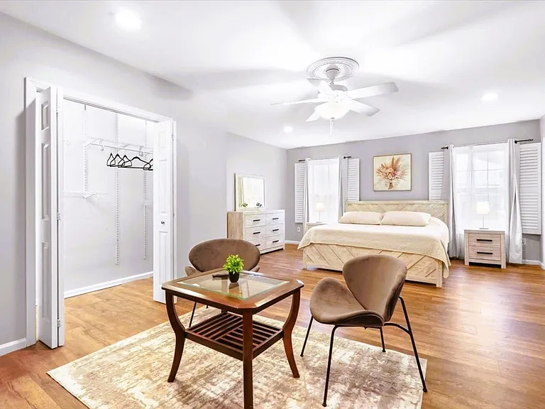 Master bedroom with king-size bed, blackout curtains, two closets, and a seating area with large, 65' TV. It has a full en-suite bathroom. The room and bathroom are wheelchair accessible, with 30-inch doorways.