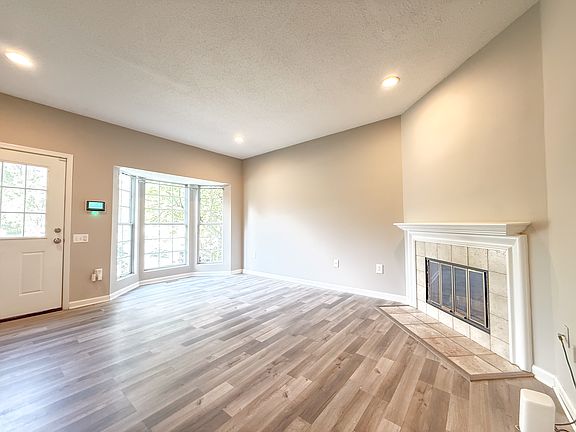 Living room with bay window and wood burning fireplace