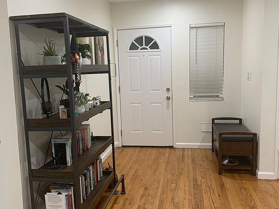 Entry way from the front door that leads into the living room. On the wall adjacent to the front door, there is a switch for the BRAND NEW QuietCool Whole House Fan.