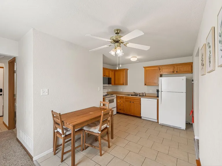 Efficient eat-in kitchen with ample wood cabinetry, full-size appliances, and a dedicated dining nook for everyday meals.